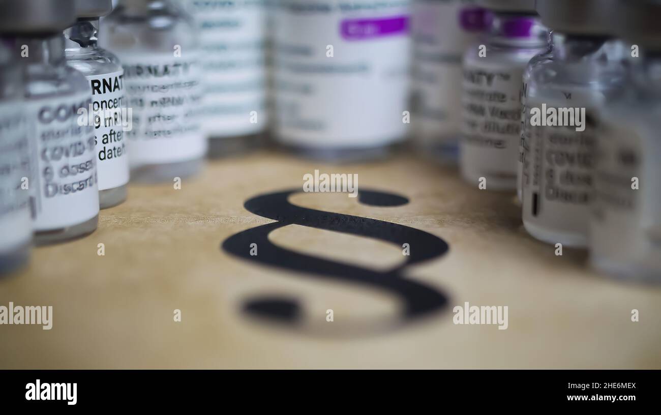 Viersen, Germany - December 9. 2021: Closeup of paragraph symbol with covid-19 vaccination vials Stock Photo