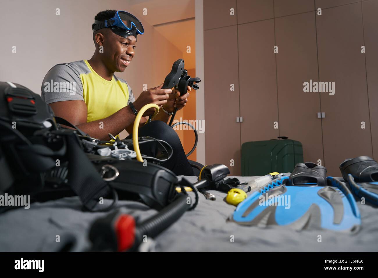 Cheerful man smiling while working with scuba set Stock Photo