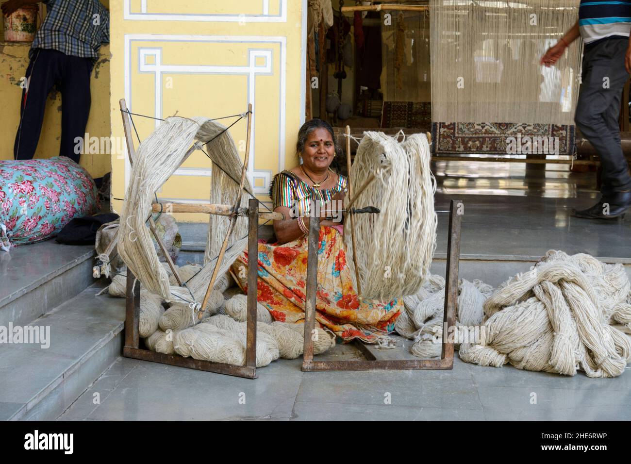 Woman spinning wool for making traditional Rajasthani rugs, Jaipur, Rajasthan, India, South Asia Stock Photo