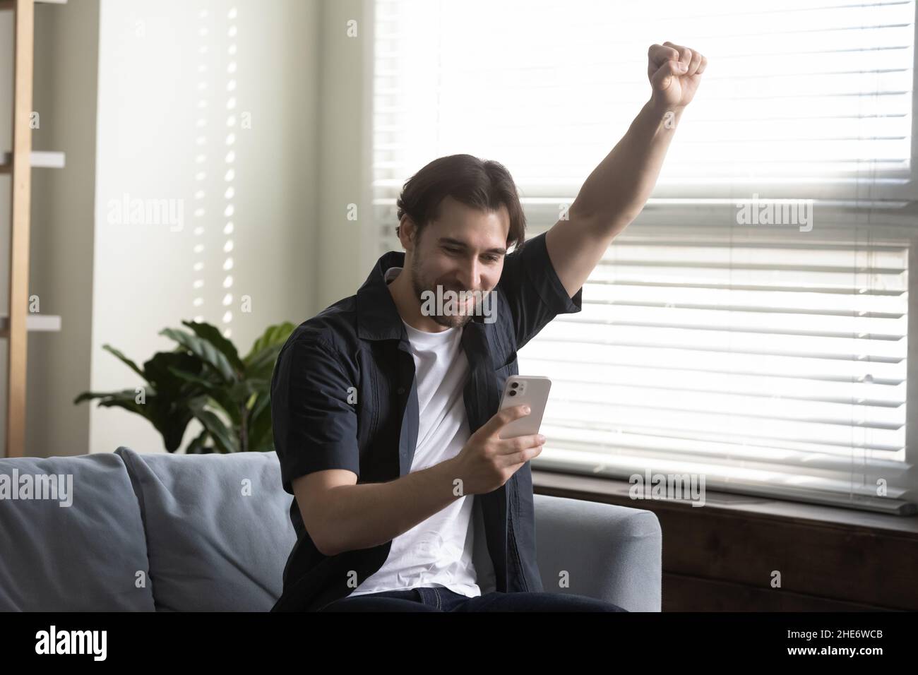 Overjoyed young 30s man celebrating online win. Stock Photo