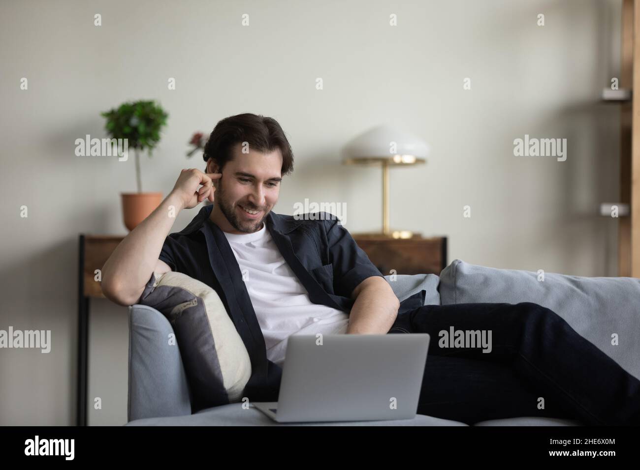 Happy relaxed millennial man using computer software apps Stock Photo ...