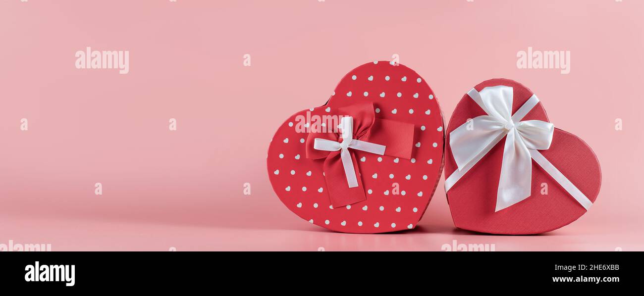 Banner with a gift box in the shape of a heart on a pink background. Valentine's Day gift concept, wide banner with space for text. Concept - Stock Photo