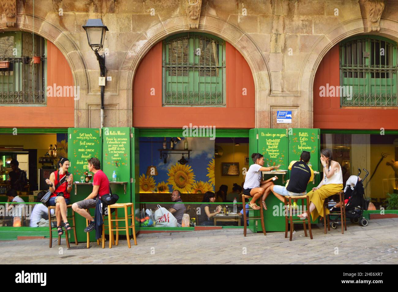 People sitting outside cafe restaurant in Barri Gotic district of Barcelona Spain. Stock Photo