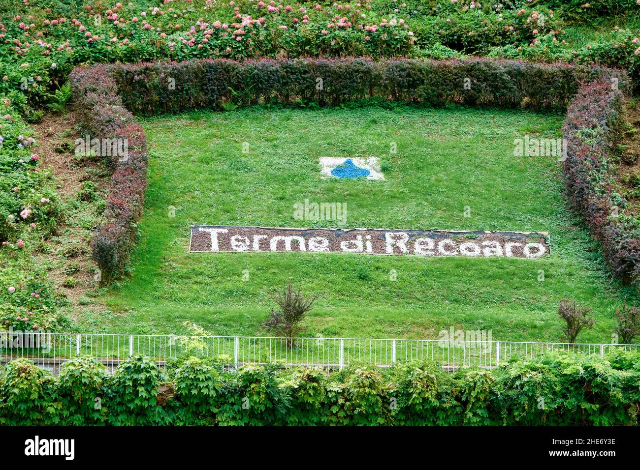 The word Recoaro Terme is written on the ground of a flower bed in the park of the thermal complex of Recoaro in Italy Stock Photo