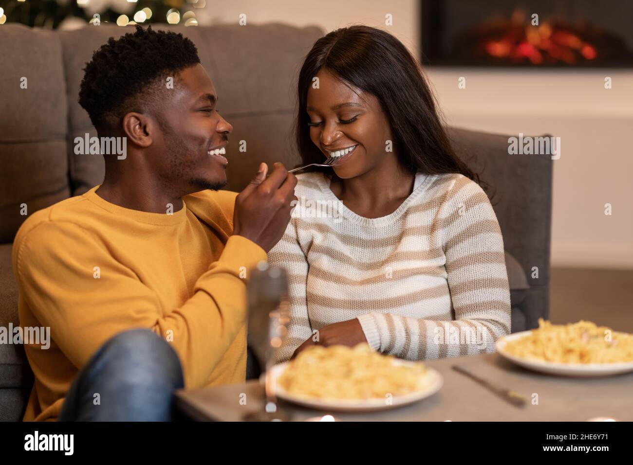 African Couple Having Romantic Dinner Eating Pasta On Valentine's Indoor Stock Photo