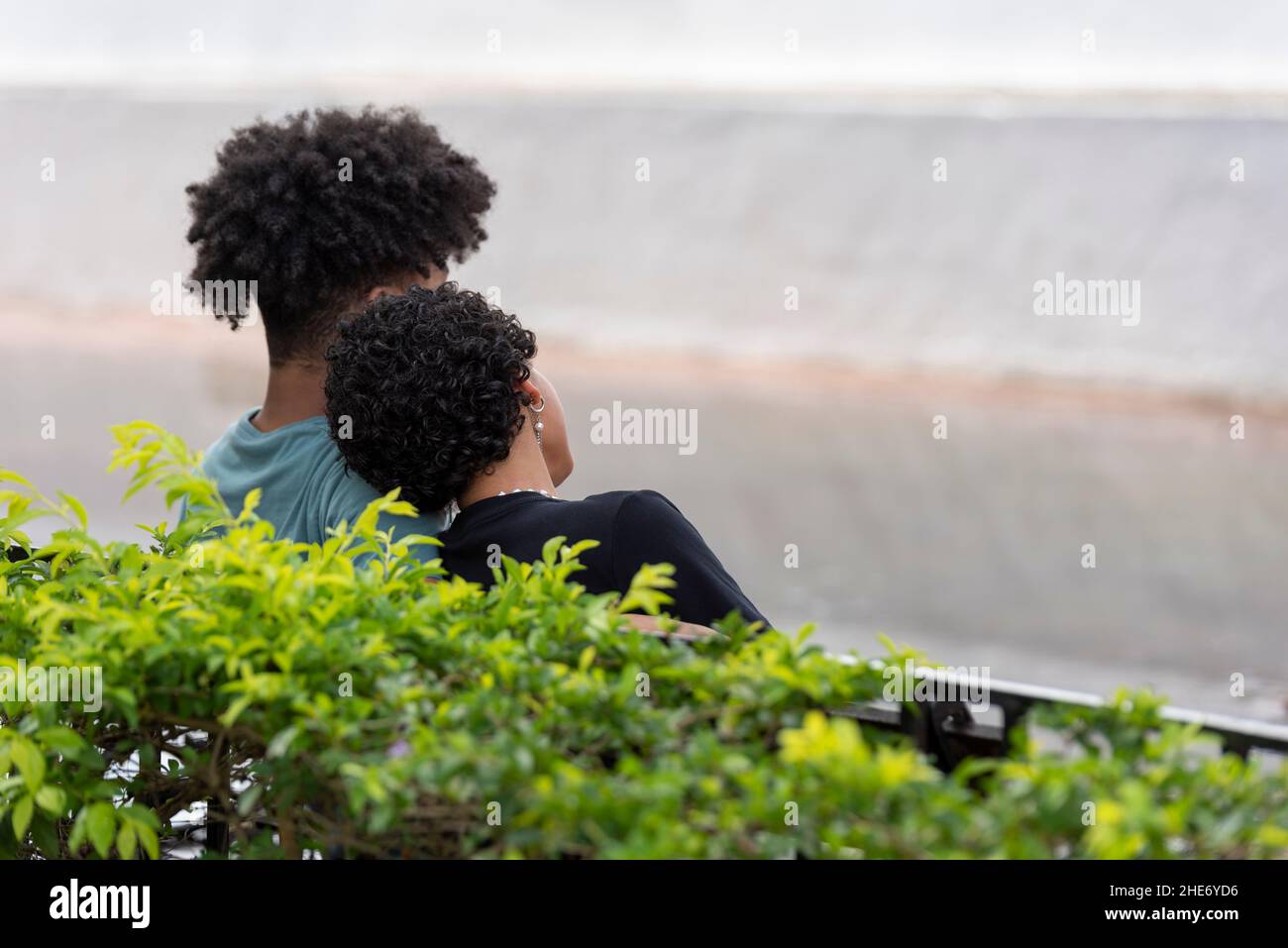Young latin couple sitting in the park, Panama Stock Photo