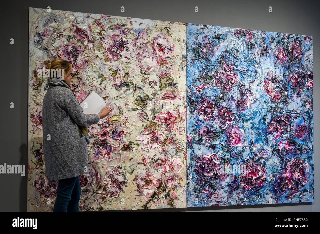 Woman admiring impasto floral paintings by Geoff Uglow in exhibition at The Scottish Gallery, Edinburgh, Scotland, UK Stock Photo