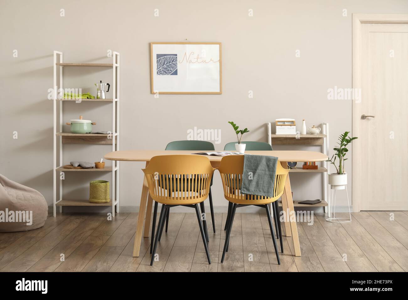 Interior of light dining room with table and shelving units Stock Photo ...