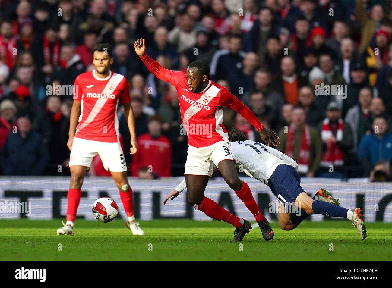 Morcambe's Toumani Diagouraga (centre) and Tottenham Hotspur's Bryan Gil Salvatierra (right) battle for the ball during the Emirates FA Cup third round match at Tottenham Hotspur Stadium, London. Picture date: Sunday January 9, 2022. Stock Photo