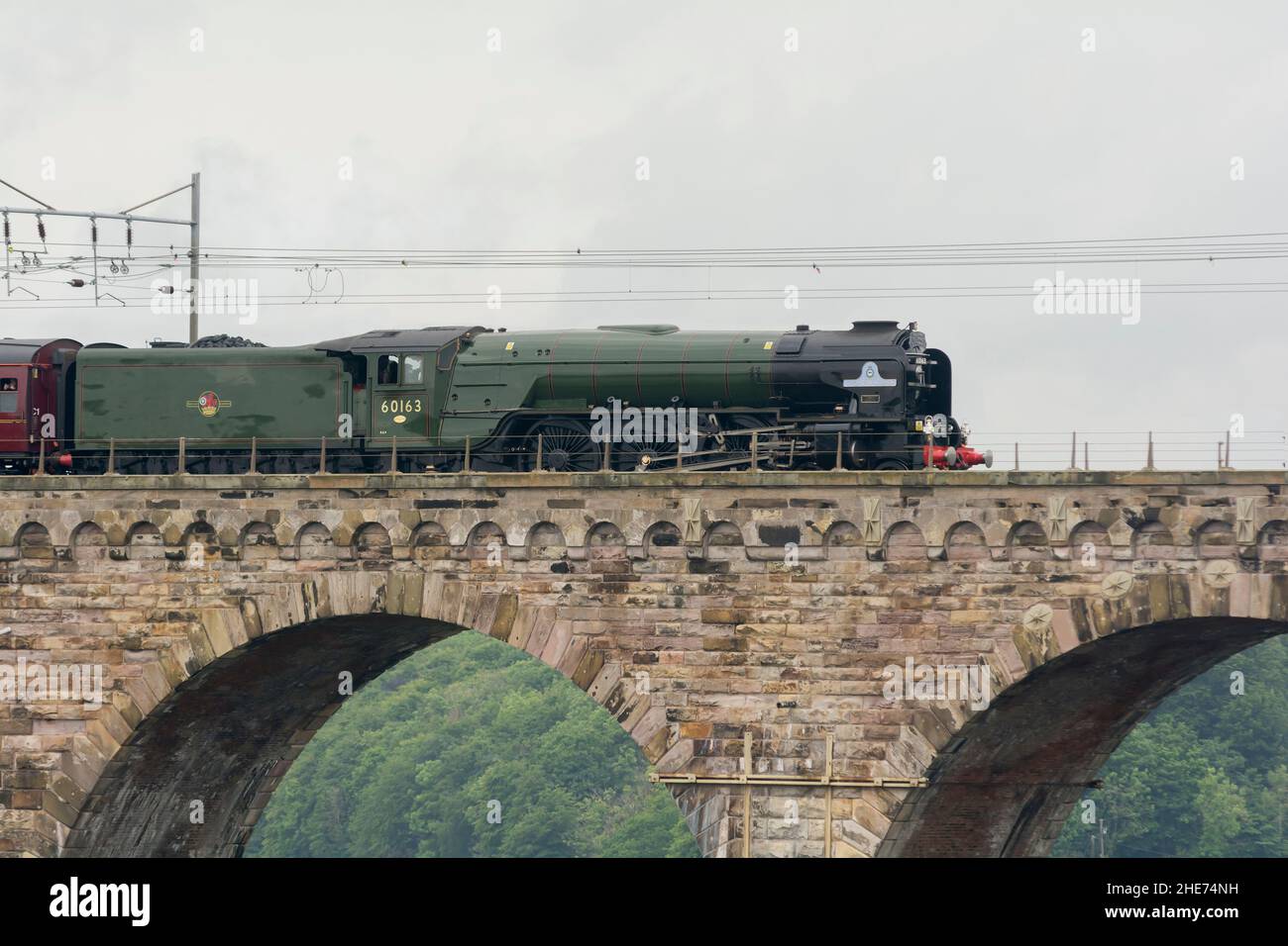 The Tornado Class A1 steam engine and heritage carriages train travelling over the railway viaduct built by Robert Stevenson in Berwick-upon-Tweed Stock Photo