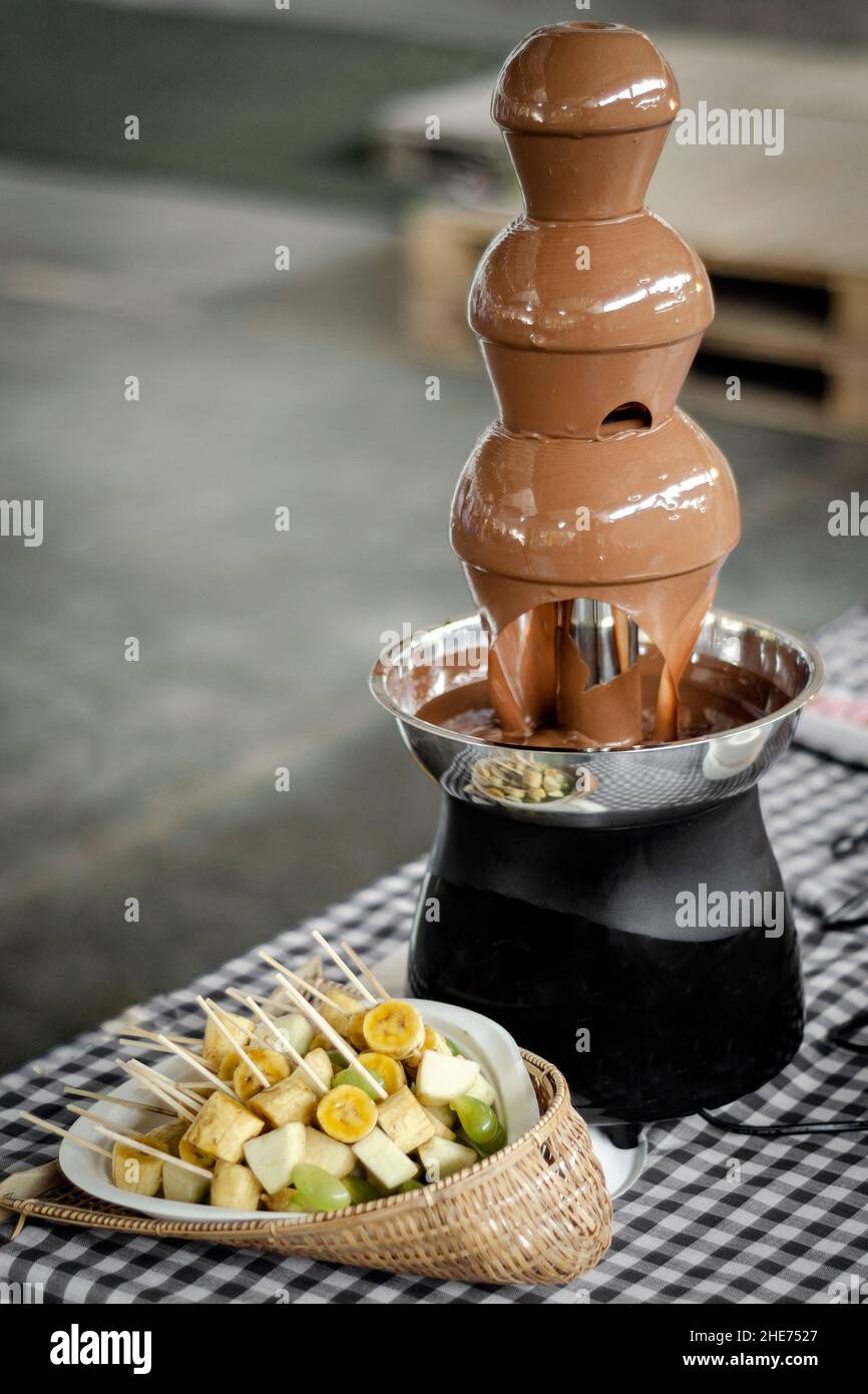 chocolate fountain catering machine with fruit skewers on rustic buffet table Stock Photo Alamy