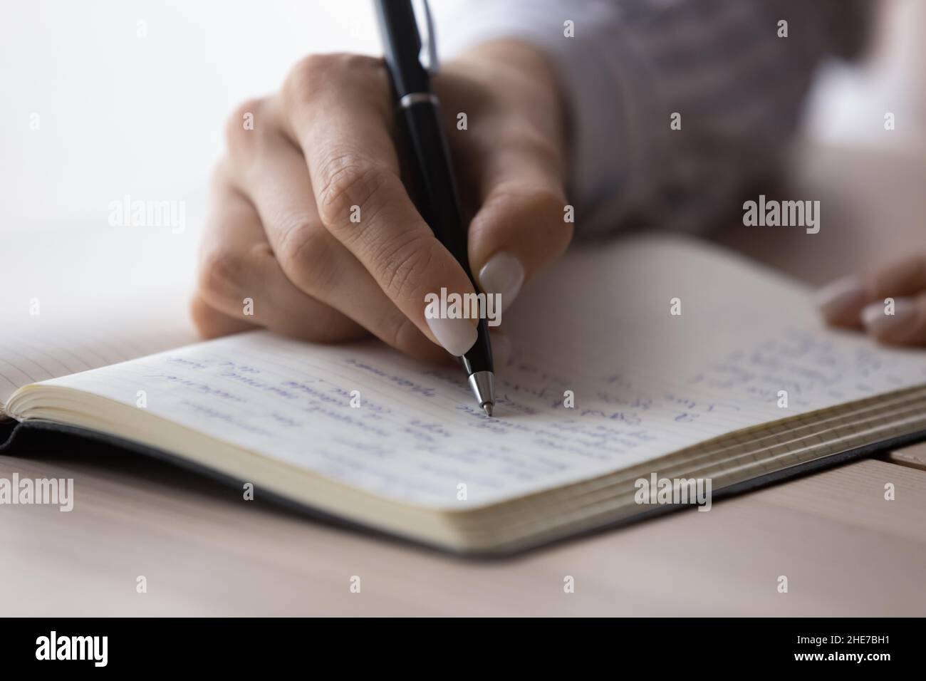 Office employee planning workday, writing list of tasks in notebook