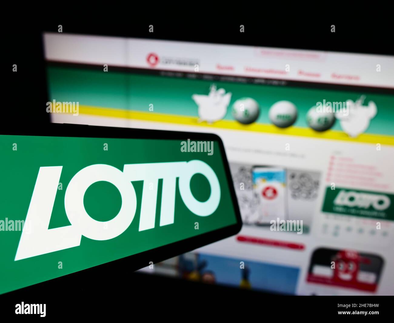 Cellphone with logo of Austrian lottery of Österreichische Lotterien GmbH on screen in front of business website. Focus on left of phone display. Stock Photo