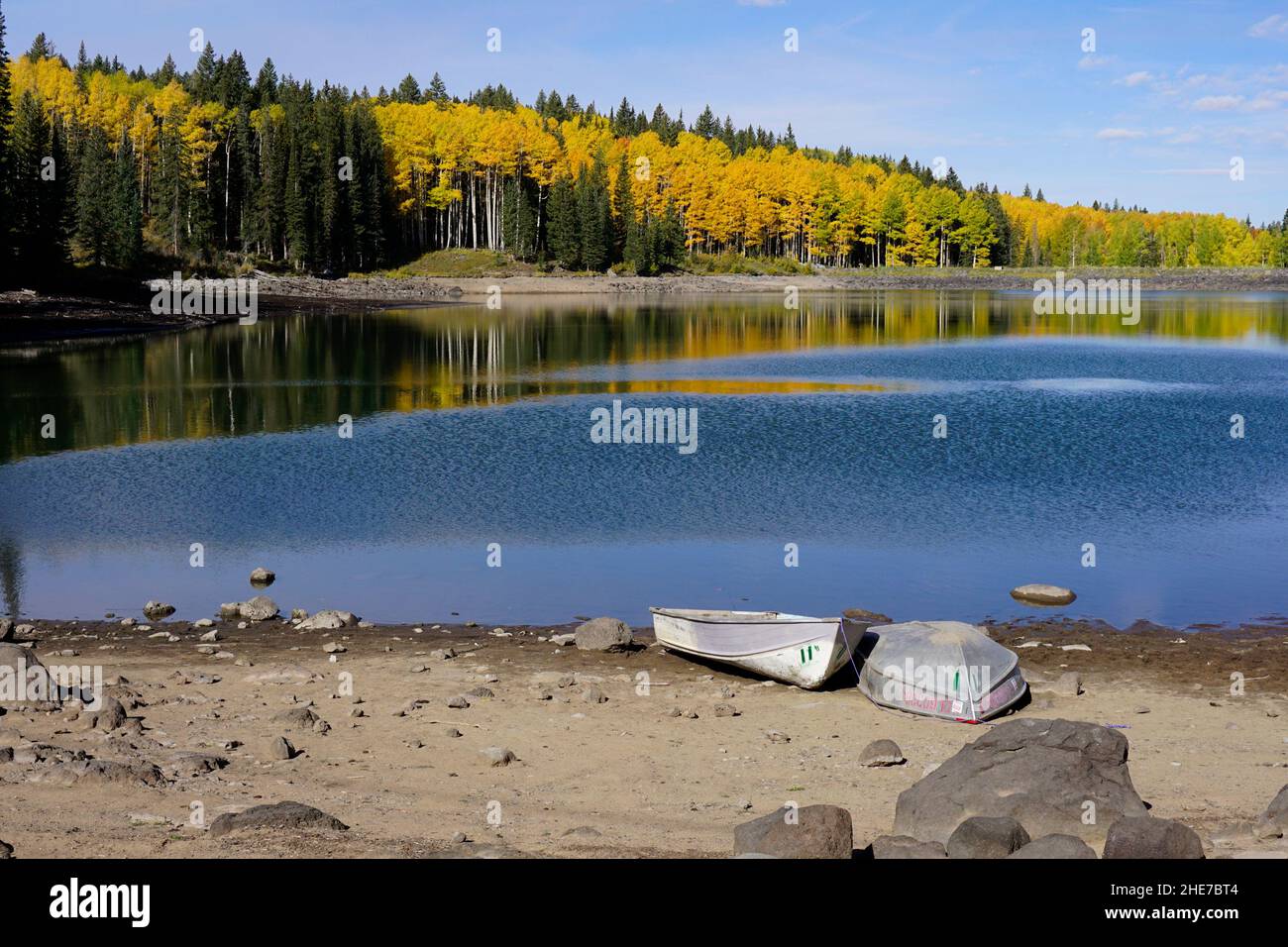 Boats on the shore of Sunset Lake surrounded by fall color in Grand Mesa National Forest. Stock Photo