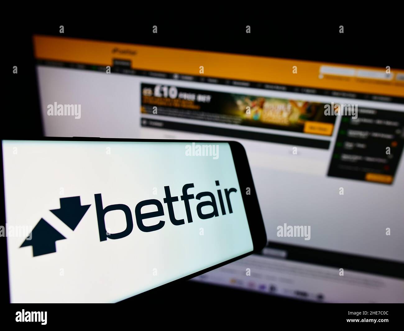Mobile phone with logo of British online gambling company Betfair on screen in front of business website. Focus on center-right of phone display. Stock Photo