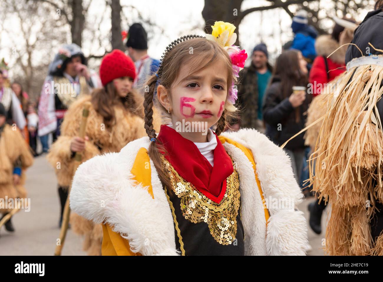Bulgarian child. Kukeri little girl dancer with intricate costume at the traditional annual festival. Kukeri is a centuries-old tradition intended to chase evil spirits away and to invite good, held around early winter or midwinter. Stock Photo