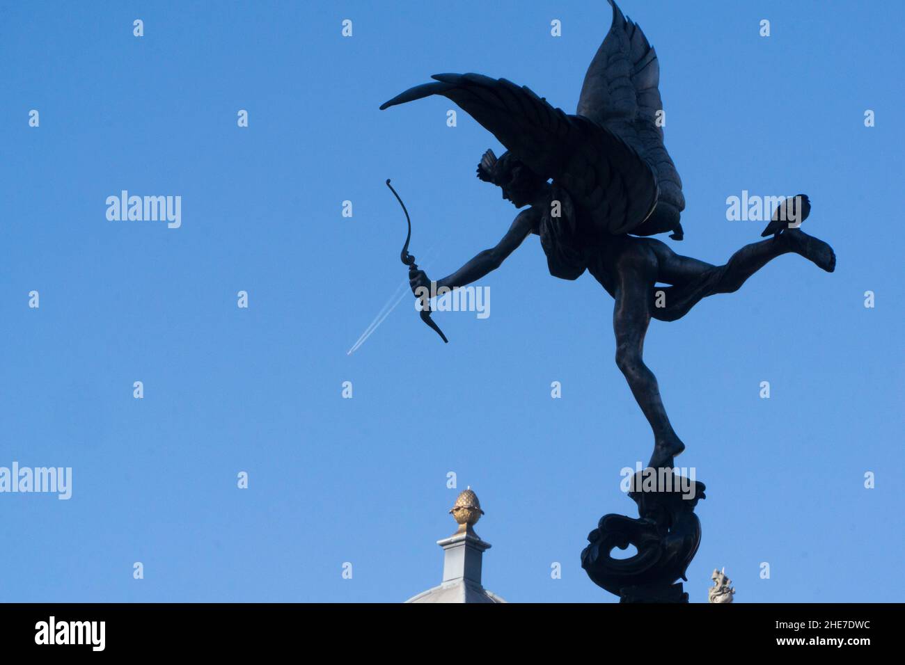 UK weather, London, 9 January 2022: The statue f Eros at Piccadilly appears to fire an aeroplane from his bow with the vapour trail forming an arrow shaft. The clear blue skies came after intense rain yesterday and encouraged tourists out into the West End. Anna Watson/Alamy Live News Stock Photo