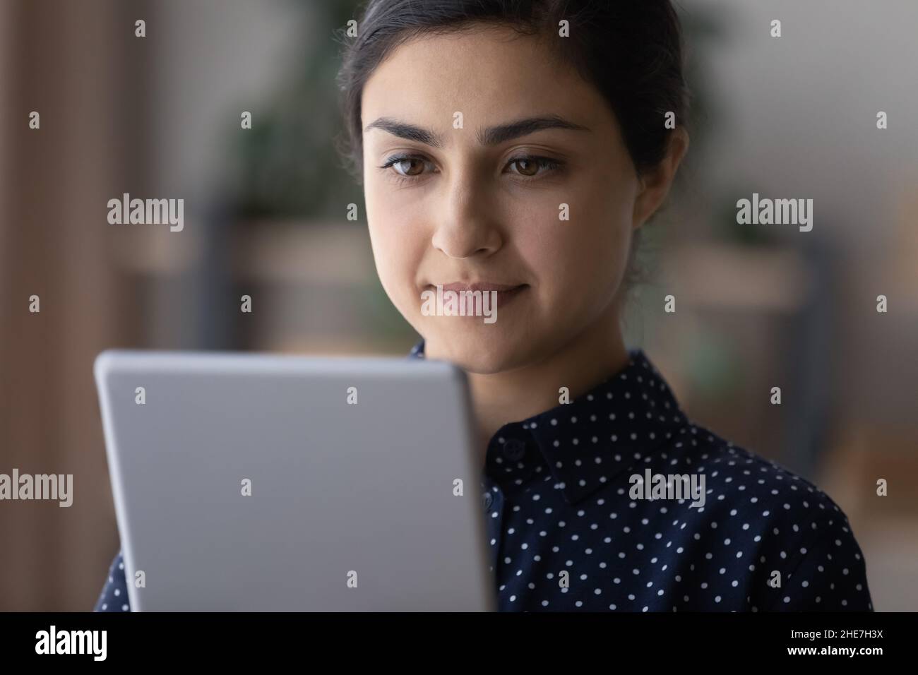 Focused millennial young woman using tablet computer Stock Photo