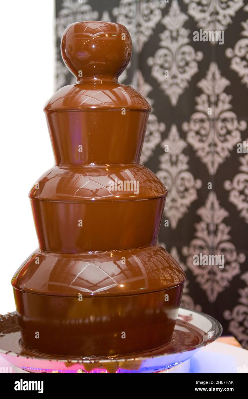 melted chocolate fountain at a celebration to eat with fruit Stock