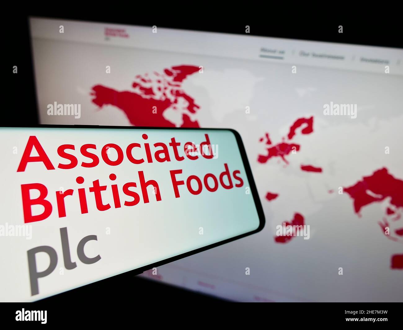 Cellphone with logo of company Associated British Foods plc (ABF) on screen in front of business website. Focus on center of phone display. Stock Photo