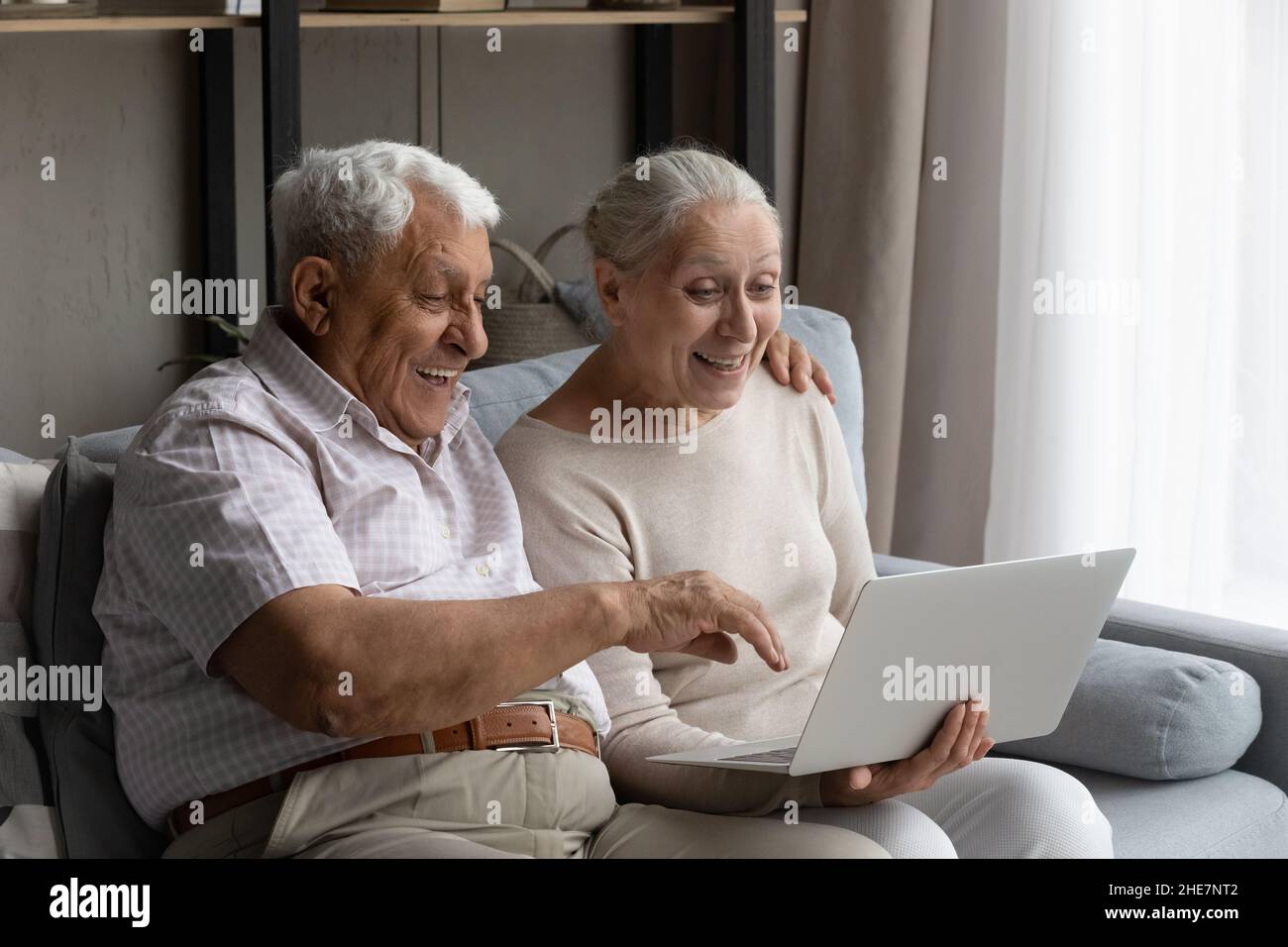 Surprised happy old family couple using computer. Stock Photo