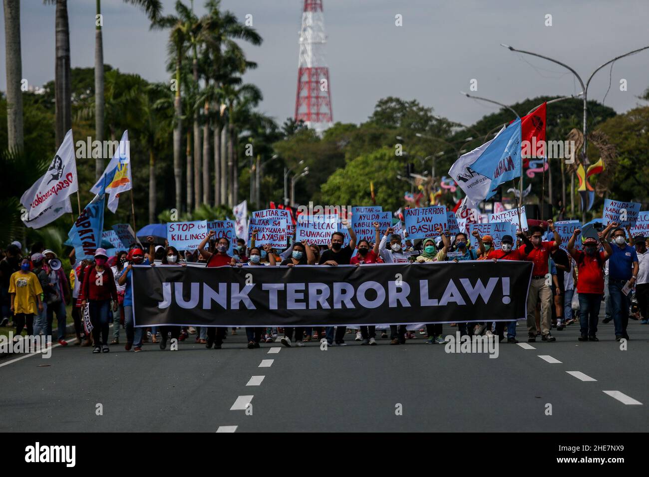 Human rights activists carry signs and offer flowers to remember fallen heroes in commemoration of the 73rd International Human Rights Day in Quezon City, Metro Manila. The monument honors the martyrs and heroes who struggled against the 21-year dictatorship of former President Ferdinand Marcos. Philippines. Stock Photo