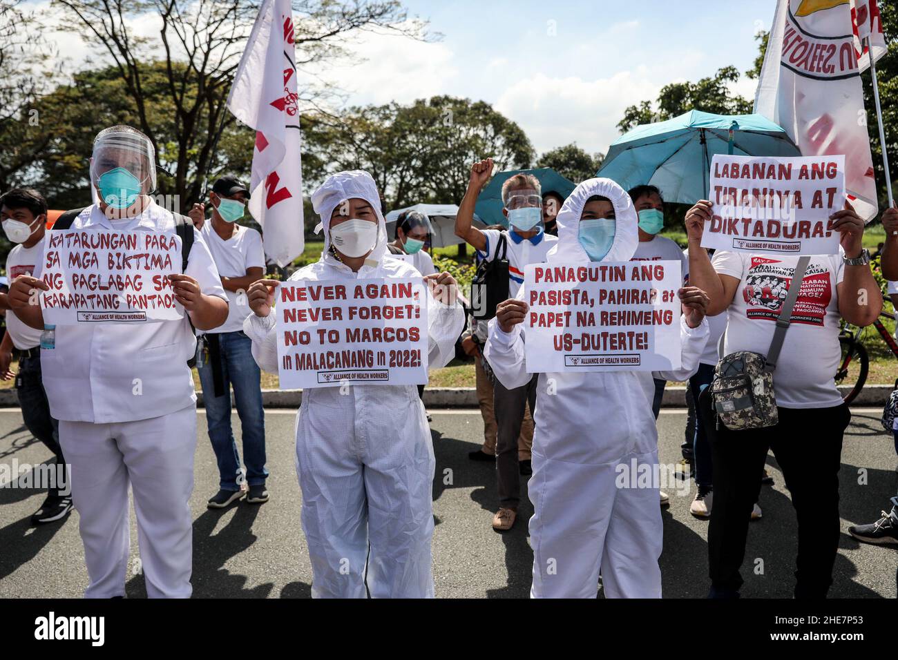 Health workers wearing protective equipment carry signs during a protest to mark the 73rd International Human Rights Day at the University of the Philippines in Quezon City, Metro Manila. Thousands of activists from various groups rallied against the implementation of the controversial anti-terror law and alleged human rights violations, including attacks on media workers and alleged extrajudicial killings in President Duterte's crackdown against illegal drugs. Philippines. Stock Photo
