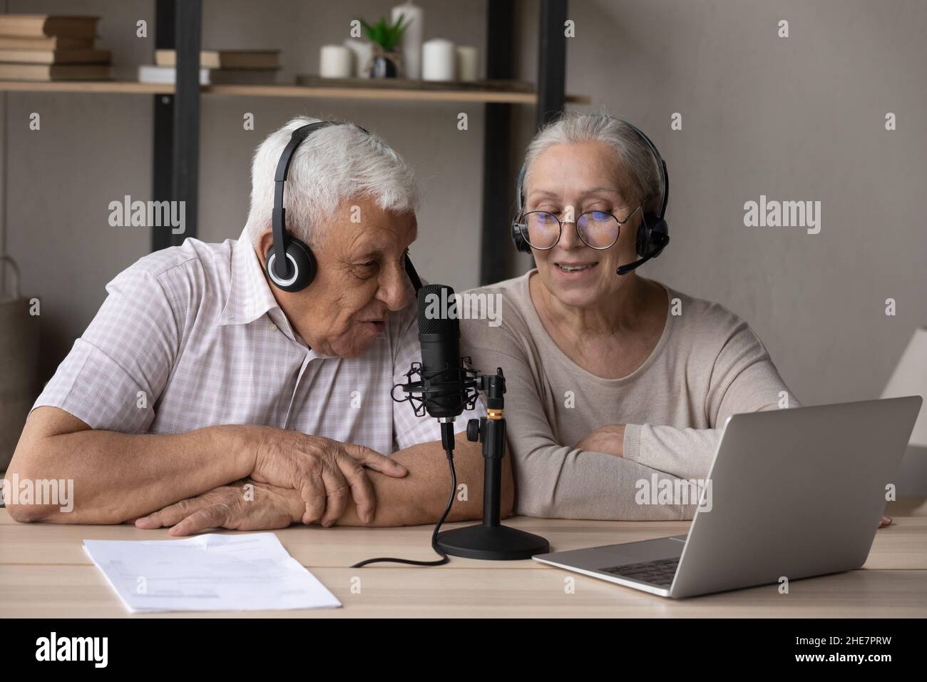 Happy middle aged old couple voice acting at home. Stock Photo