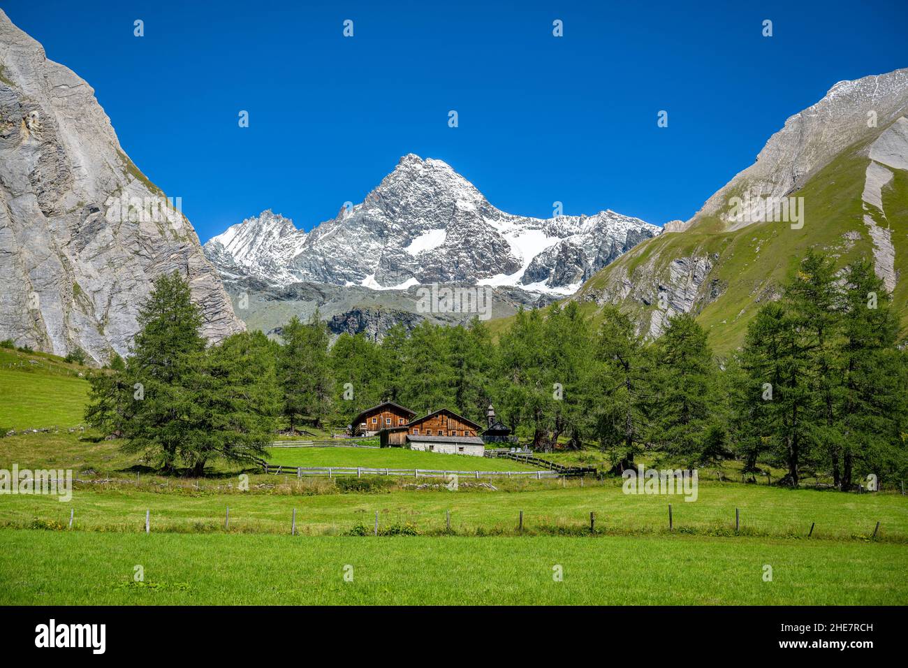 Idyllic alpine pasture with alpine huts in front of the imposing ...
