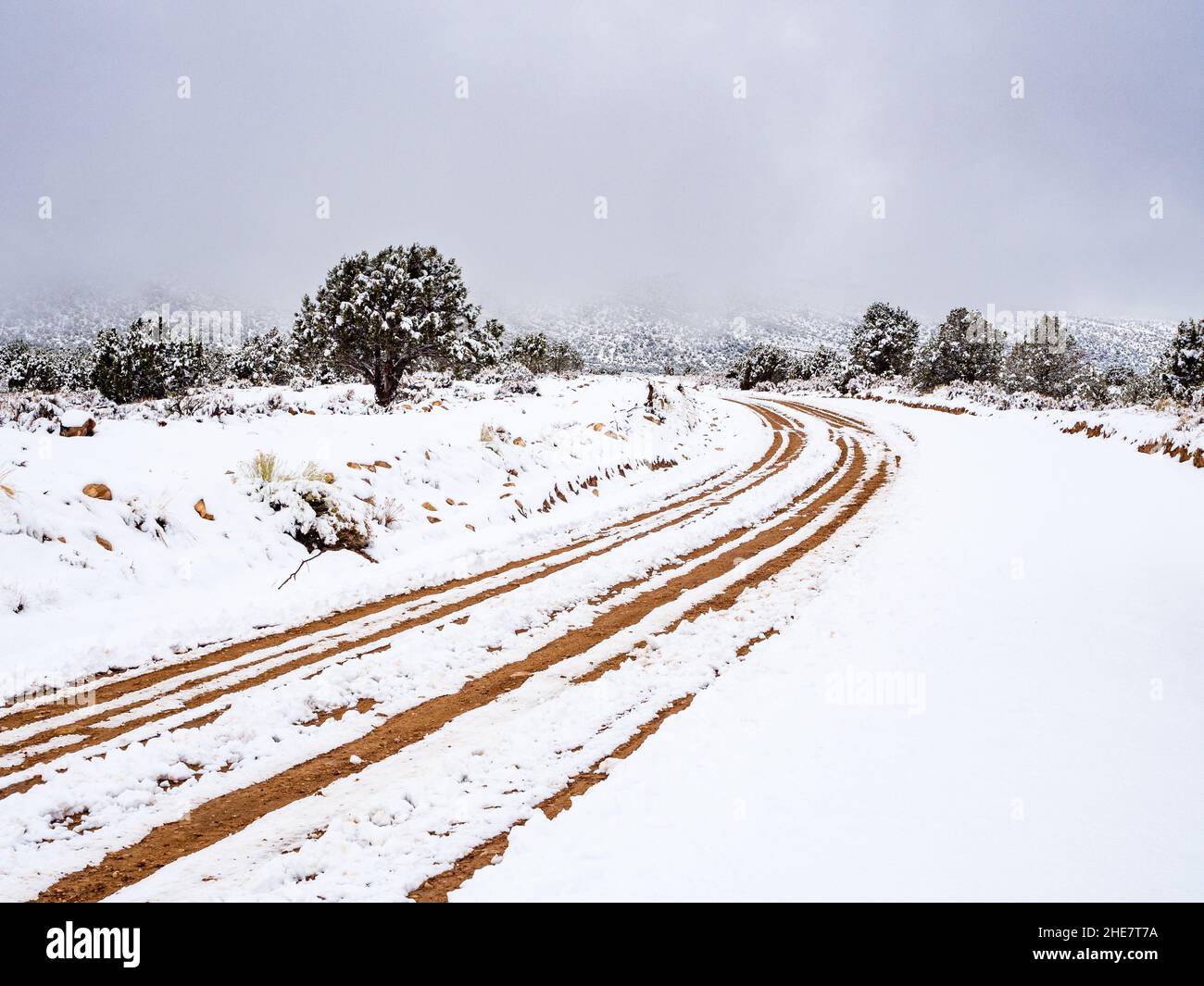 House Rock Road north of Highway 89A in Arizona with snow covering and ruts. Winter storm clouds in distance. Stock Photo