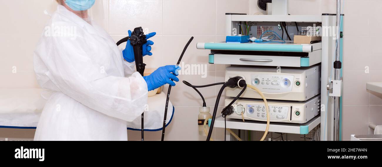 Doctor gastroenterologist in protective clothing holding endoscope