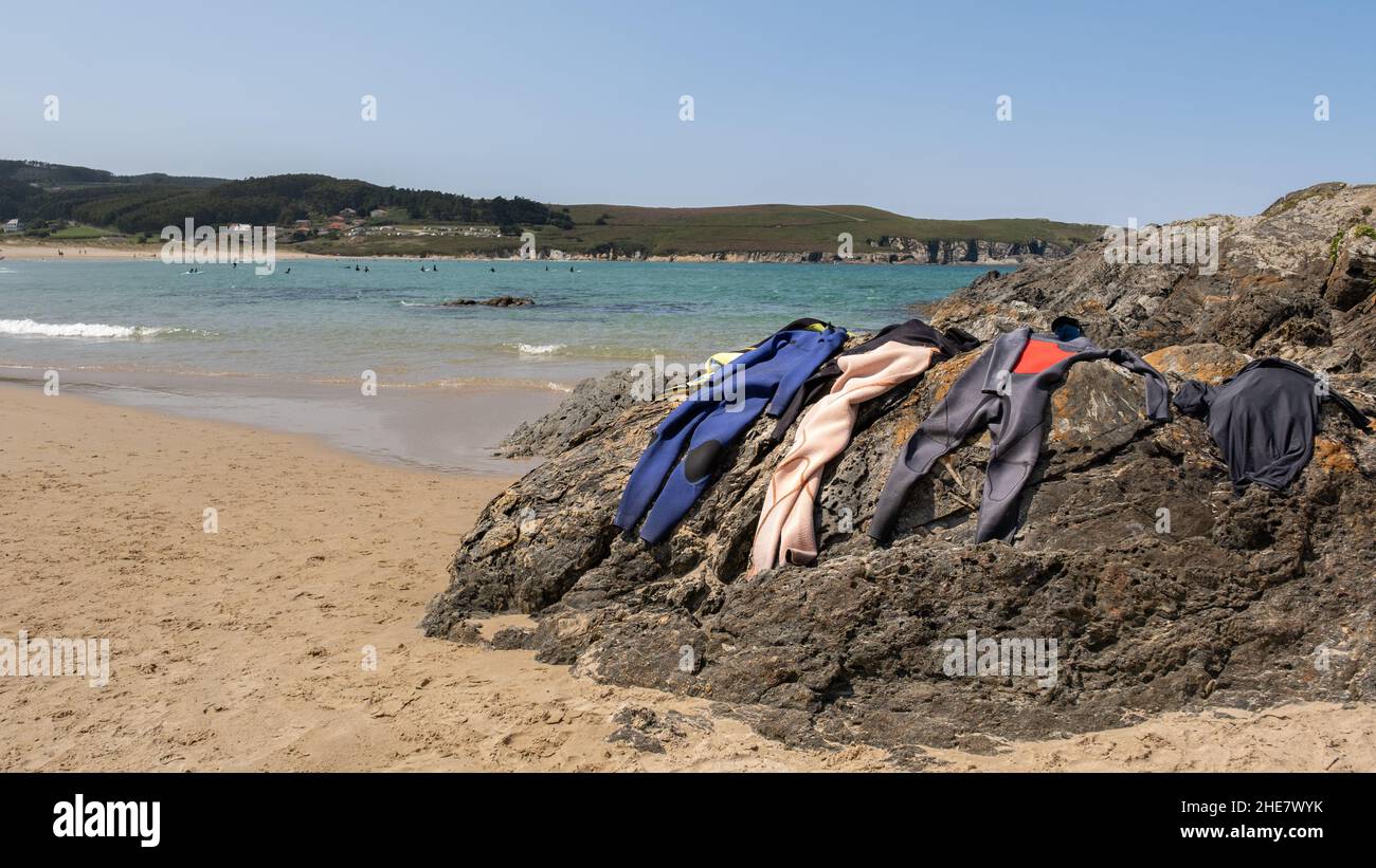 Hanging wetsuits drying in the sun on the beach Stock Photo Alamy