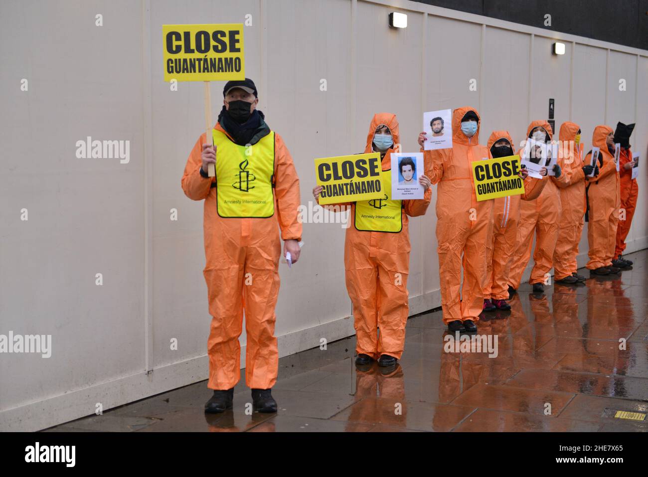 Amnesty International activists dressed up in orange jumpsuits and hoods, representing the 39 men still held in the Guantanamo Bay detention camp, marched from Parliament Square to Trafalgar Square marking 20 years of the Camp. Stock Photo