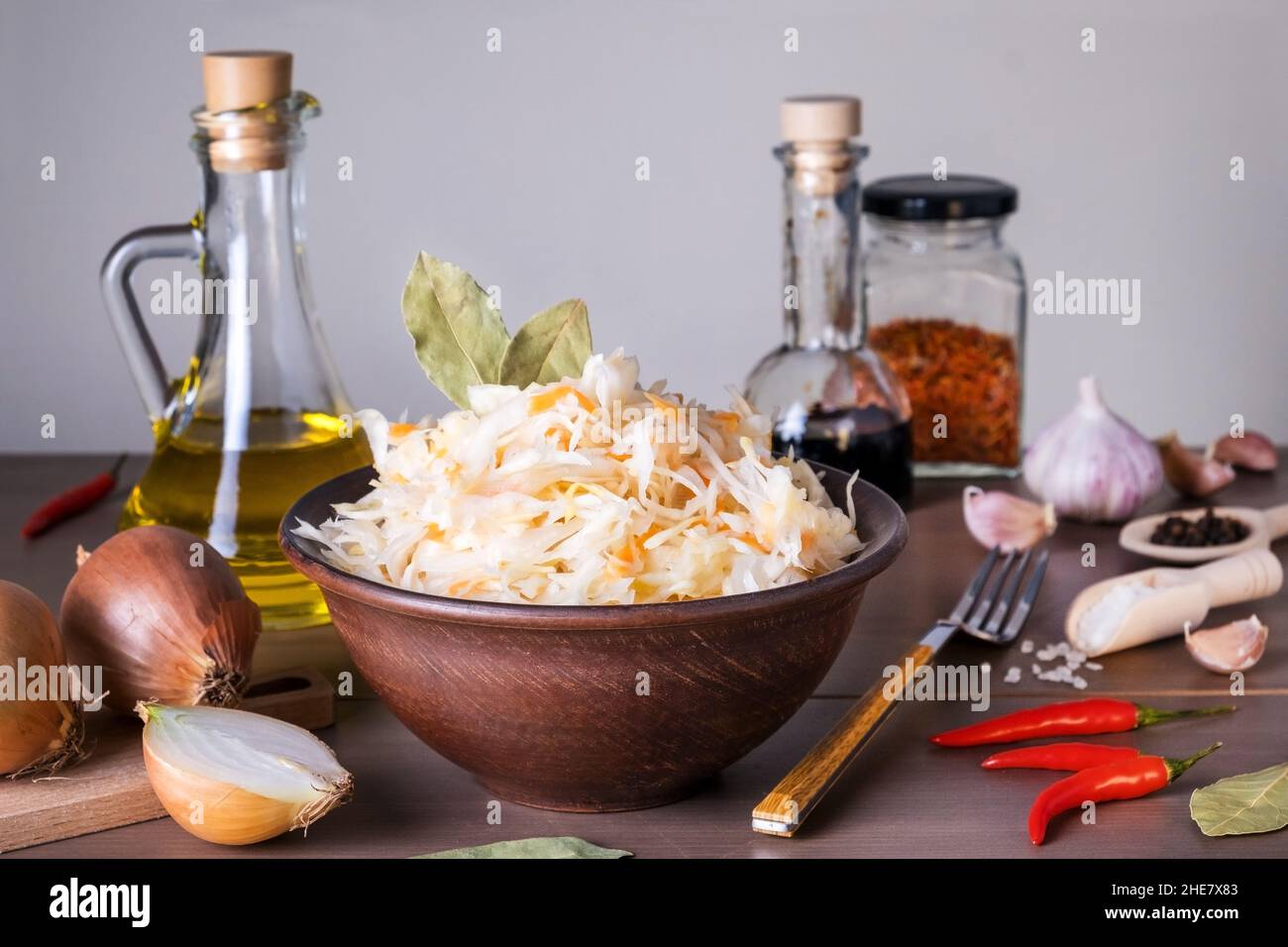 Close-up of sauerkraut fermented cabbage in ceramic sauerkraut bowl on table with spices and ingredients. Healthy healthy food. Russian kitchen. Selec Stock Photo