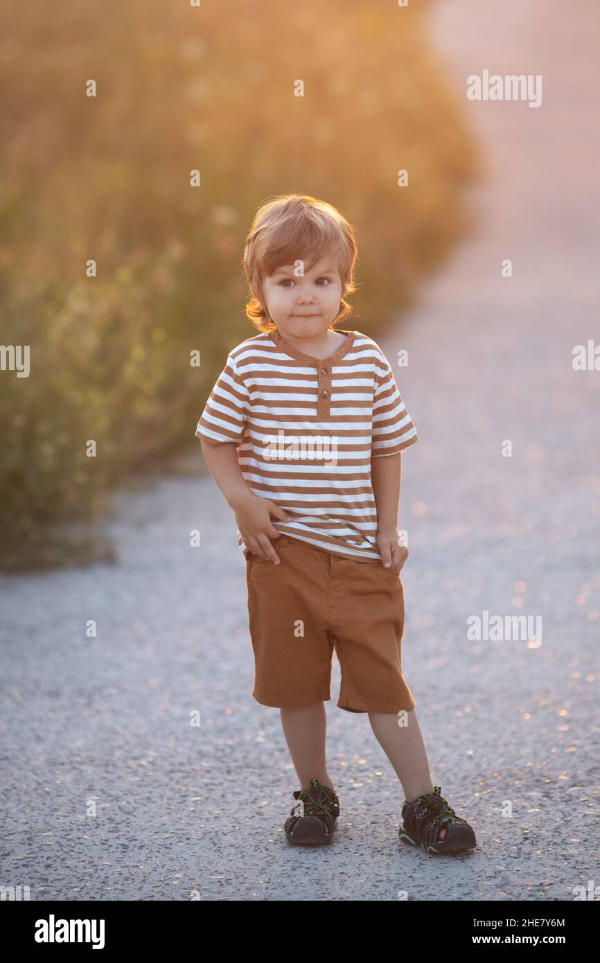 Cute caucasian blond toddler boy walking alone at clothes retail