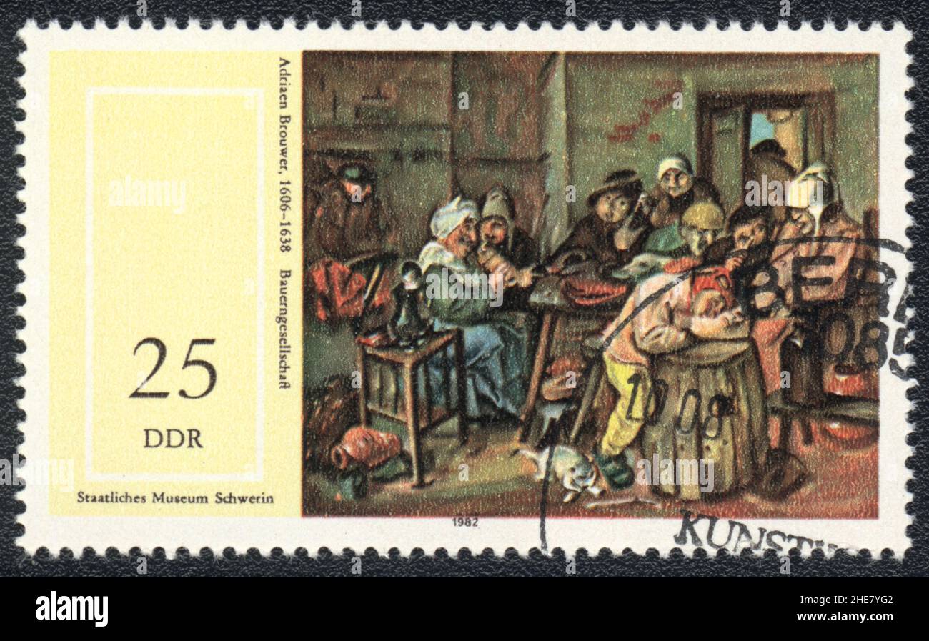 A stamp printed in DDR  shows the painting 'Farmers Company' by Adriaen Brouwer (1606-1638), from the series '17th Cent. Paintings in Museum Schwerin' Stock Photo