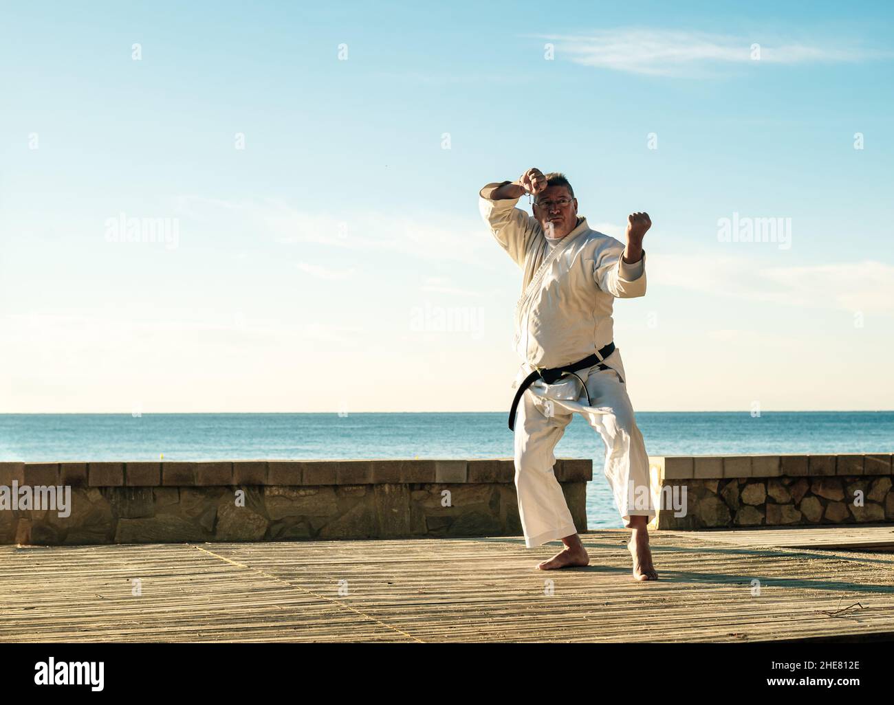 Caucasian forty licensed male with glasses practicing Karate sport