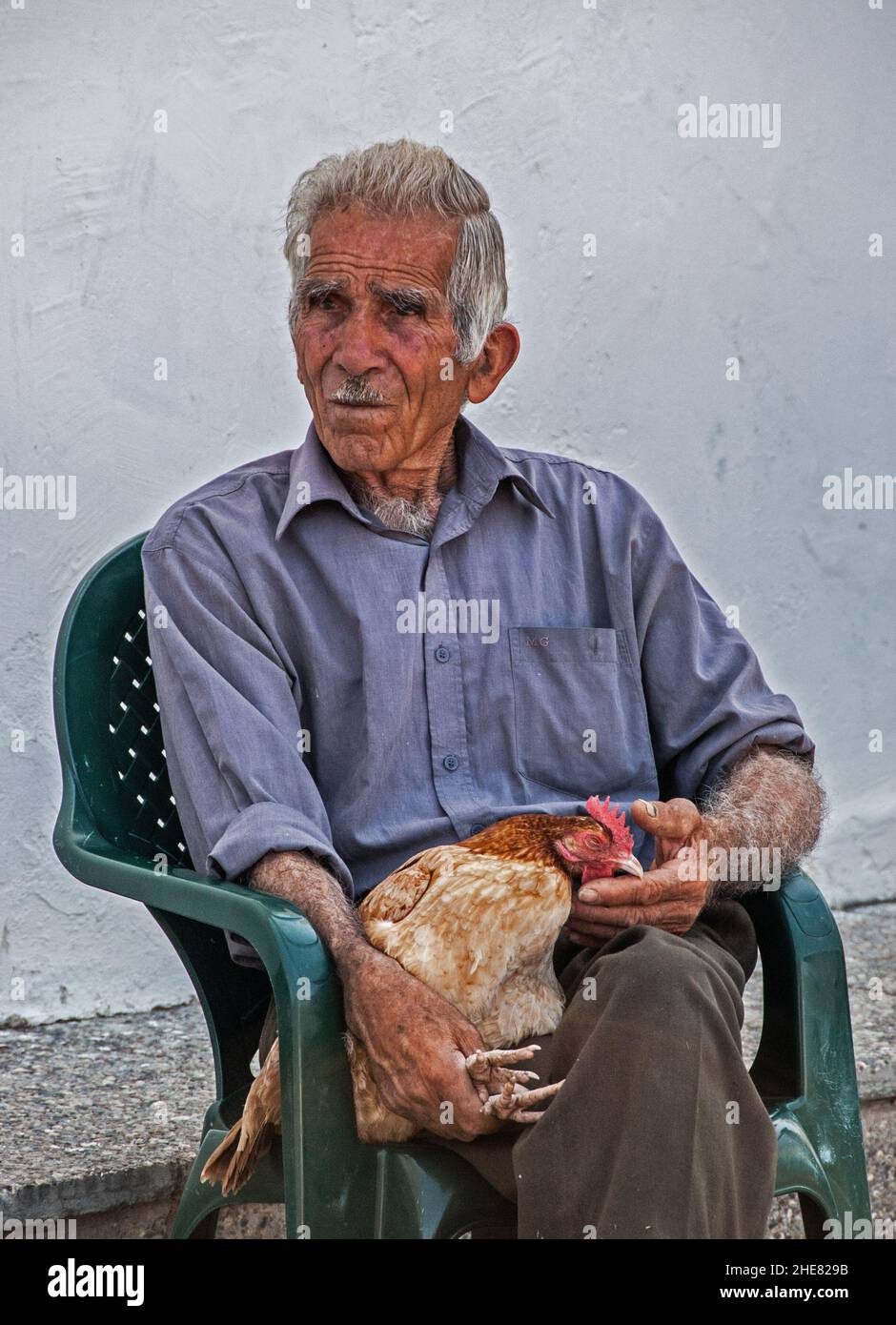 An old man selling chickens in Paphos market, Cyprus. Stock Photo