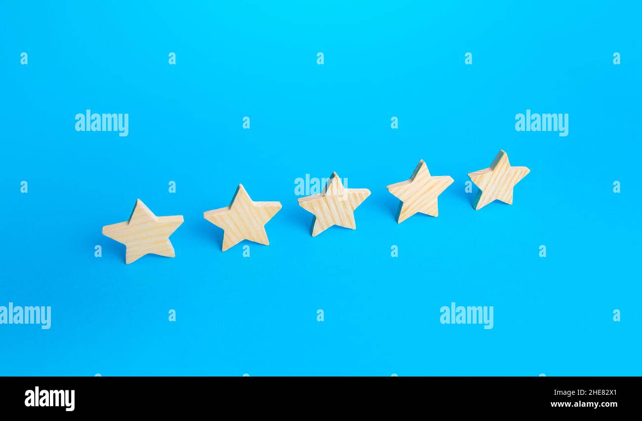 Five stars are in a row on a blue background. Rating evaluation concept. Popularity of restaurants, hotels or mobile applications. Service quality fee Stock Photo