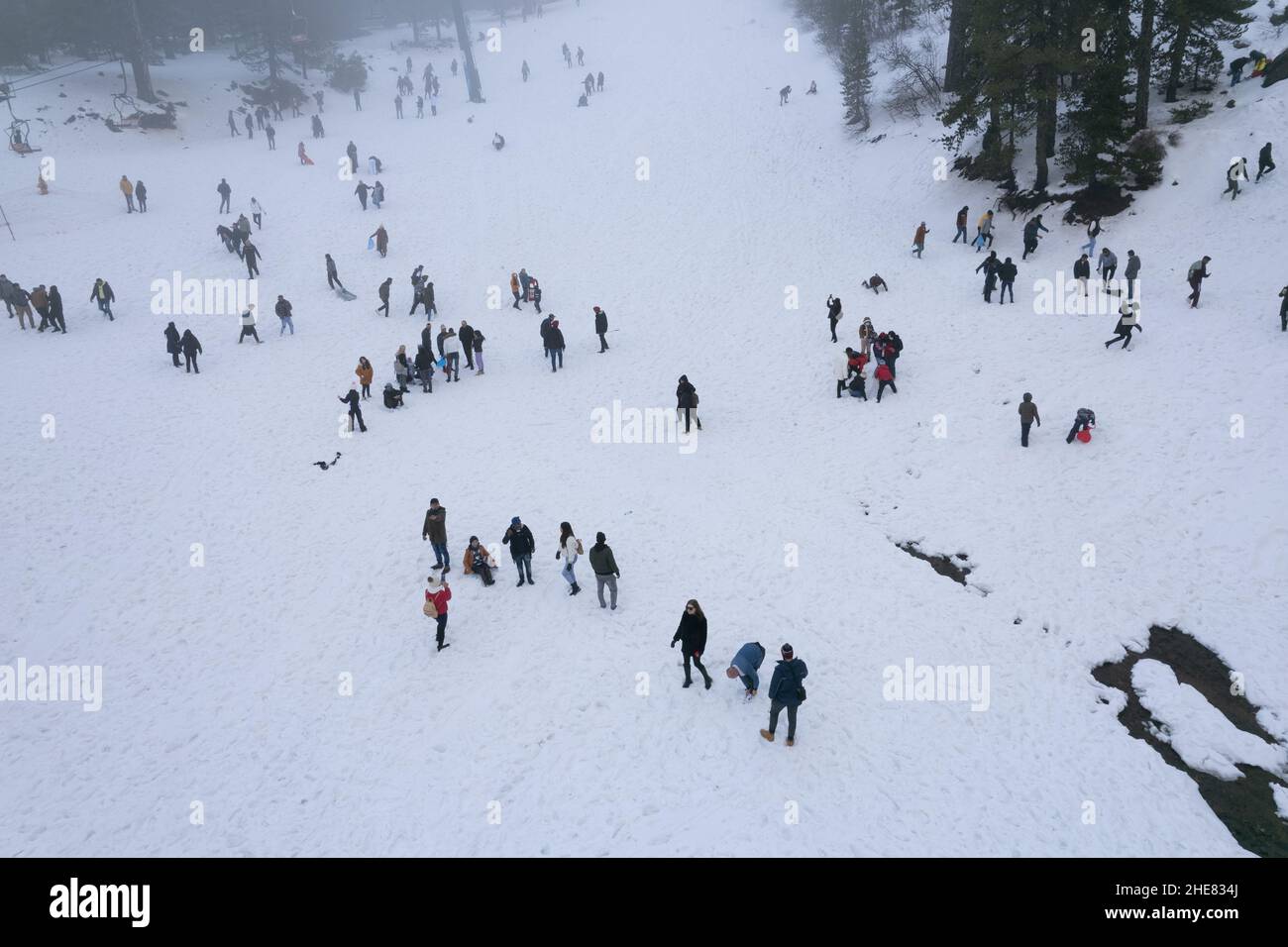 Drone aerial scene with people playing at snow in winter. Wintertime games. Stock Photo