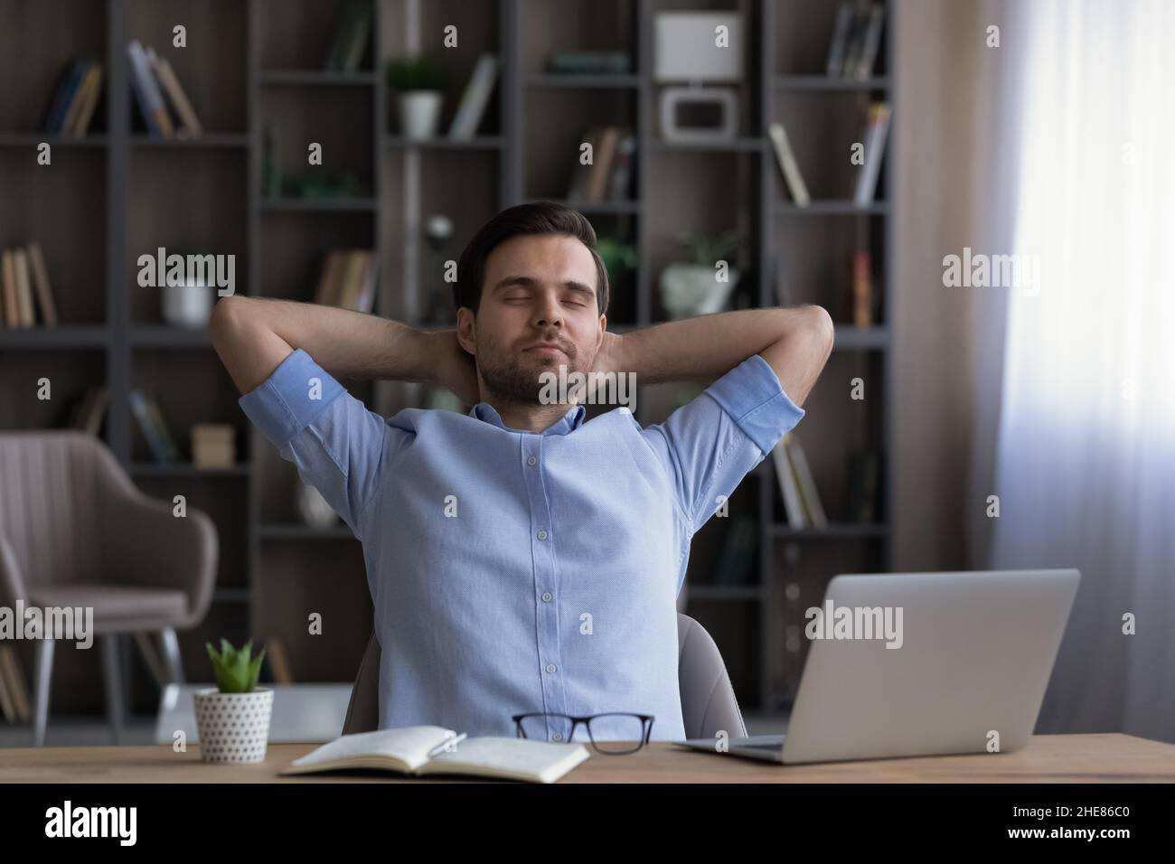 Calm businessman leaning back in office chair during break Stock Photo