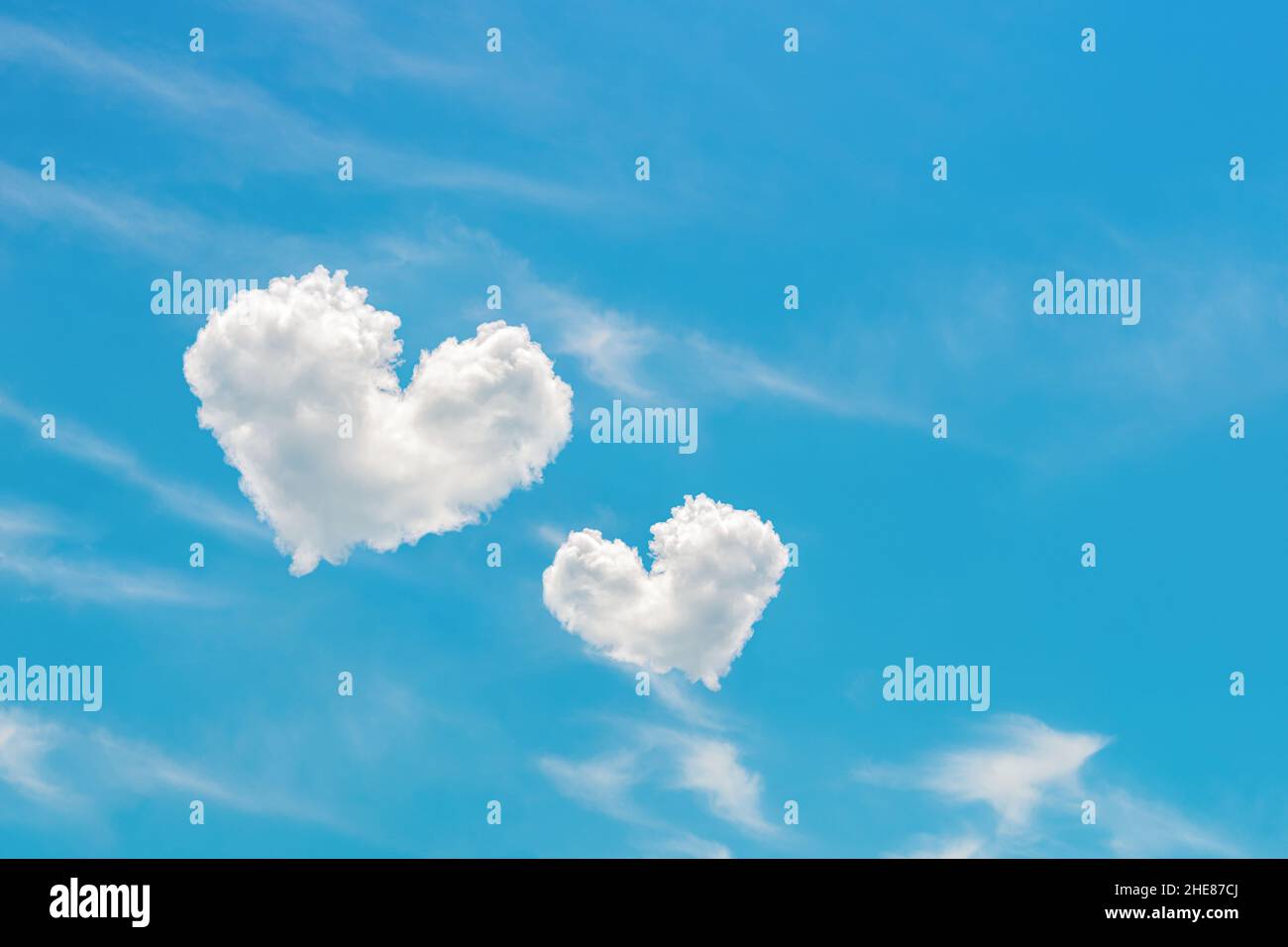 Two heart shaped clouds high in the bright blue sky. Pair of white ...