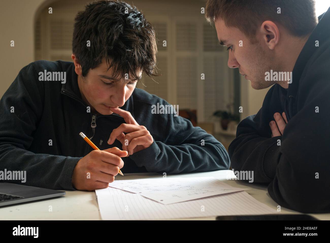 Boys study together. older student helps with homework Stock Photo