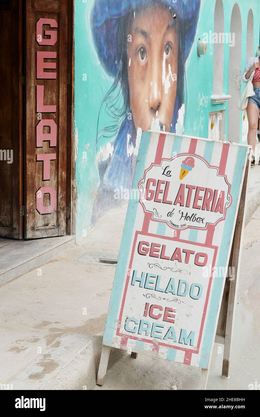 Sign outside of an ice cream parlor next to a mural on Isla Holbox, Mexico Stock Photo