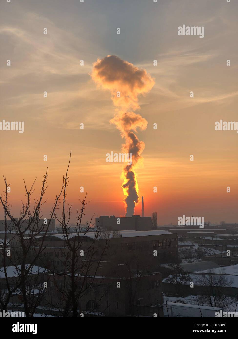 View of dense smoke coming out from the chimney at sunset sky background, Armenia Stock Photo
