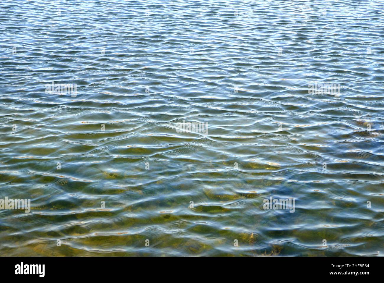 Water surface background with tiny waves and reflections Stock Photo ...