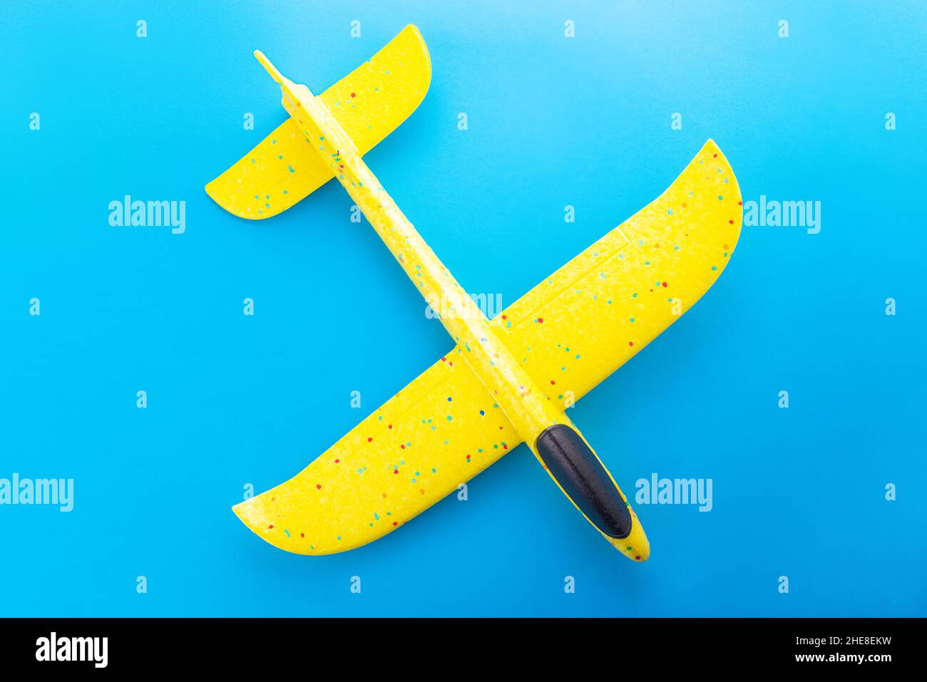 Yellow airplane toy isolated on blue background Stock Photo