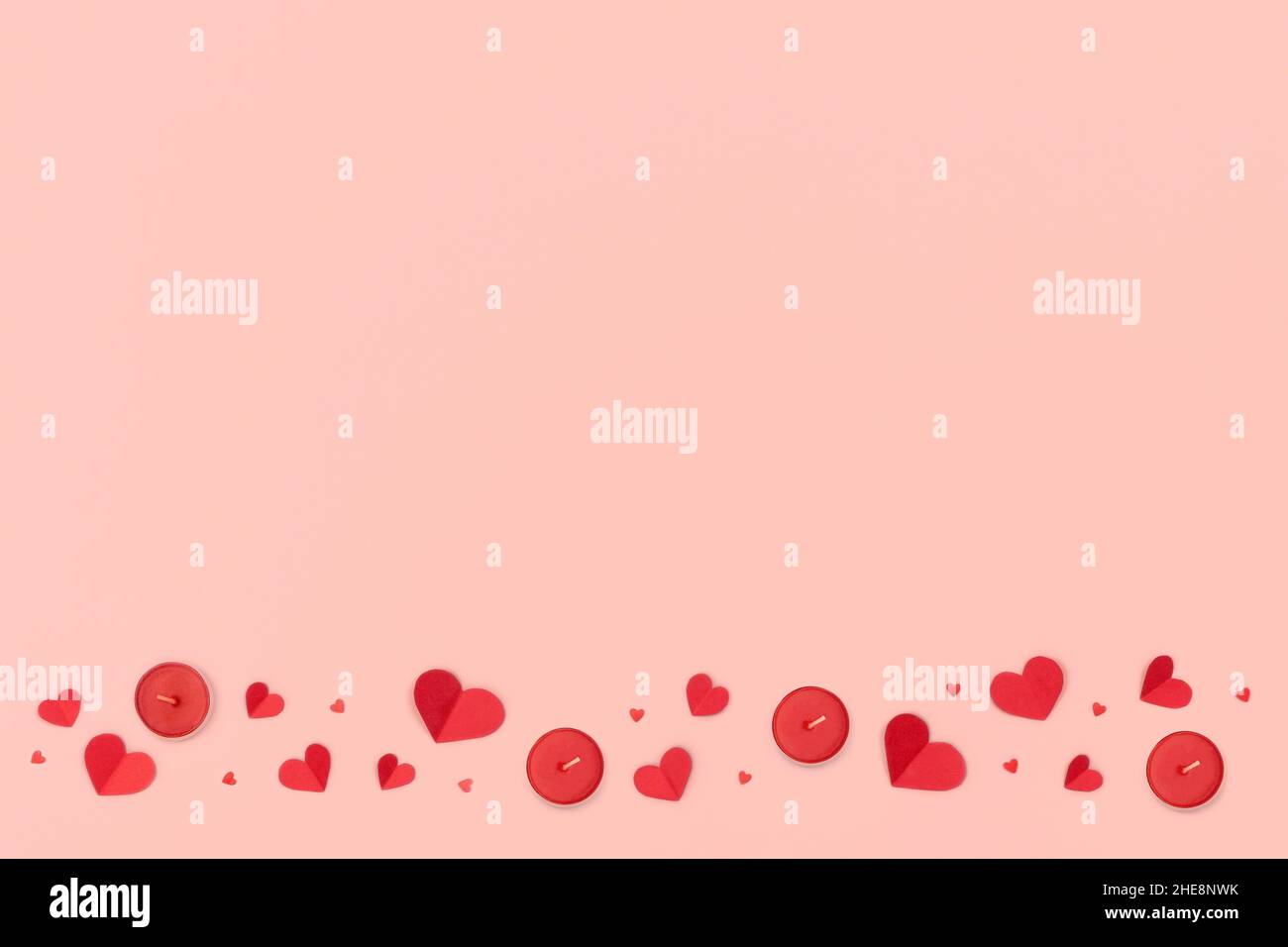 Valentines Day and Mother Day background. Red hearts and candles on pink background. Stock Photo