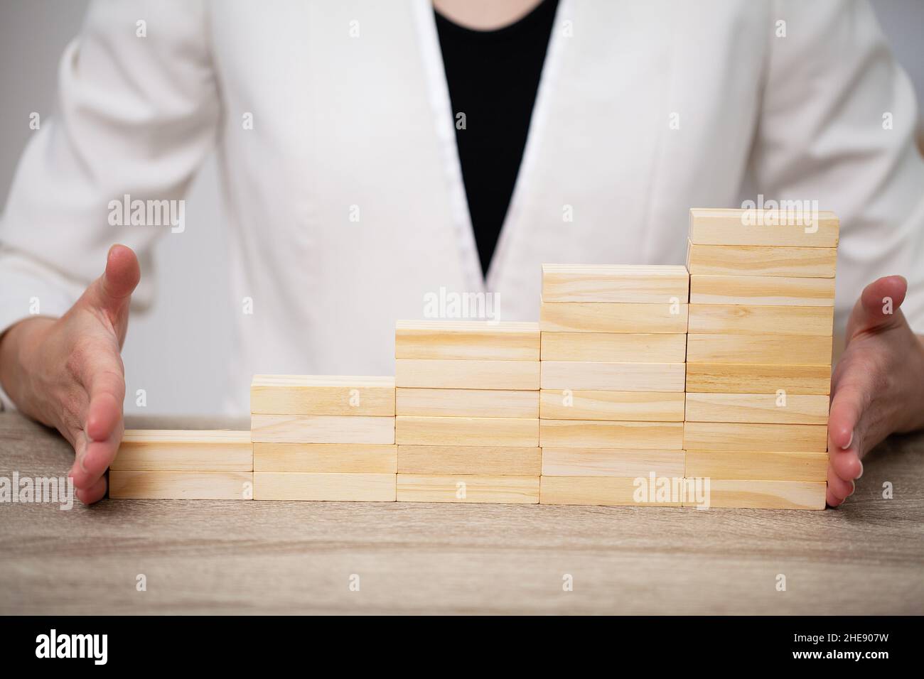 Hand putting wood cube on top of wood block stacking as step stair ...