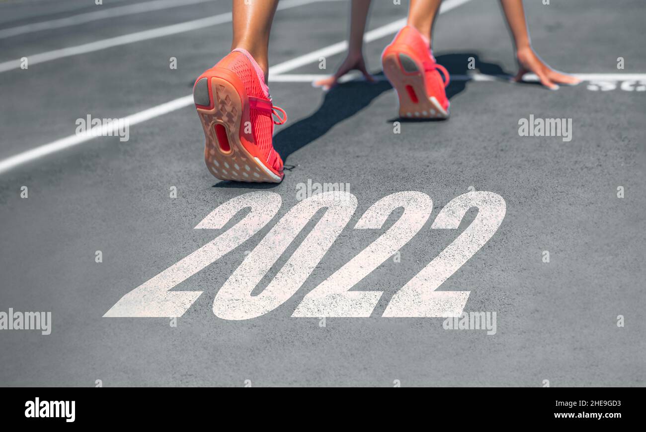 New Year 2022 ready set go fitness getting in shape woman runner at start line for goal achievement weight loss challenge banner Stock Photo